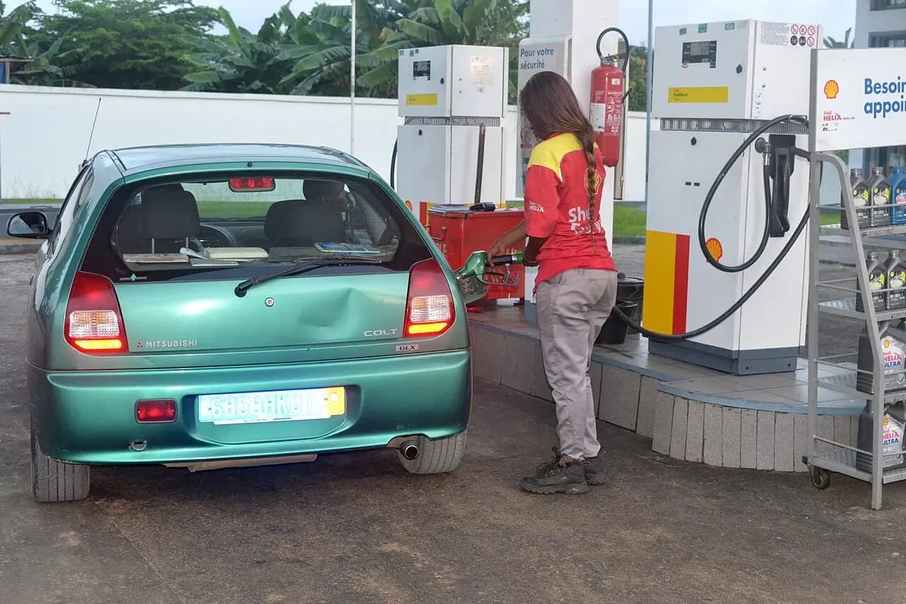 Une pompiste remplit le réservoir d’une voiture dans une station-service d’Abidjan en 2017